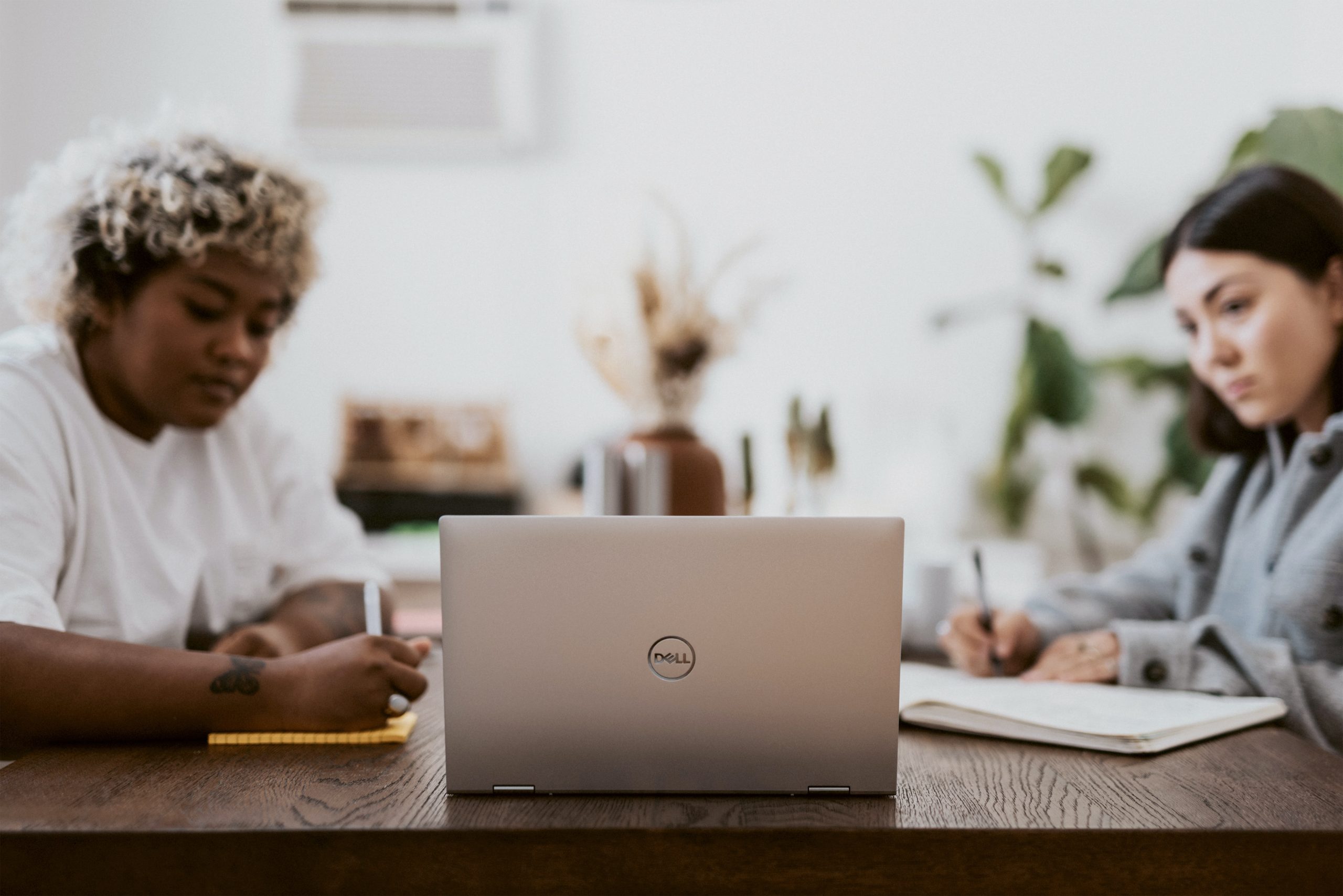 2 people looking at a laptop screen at an office